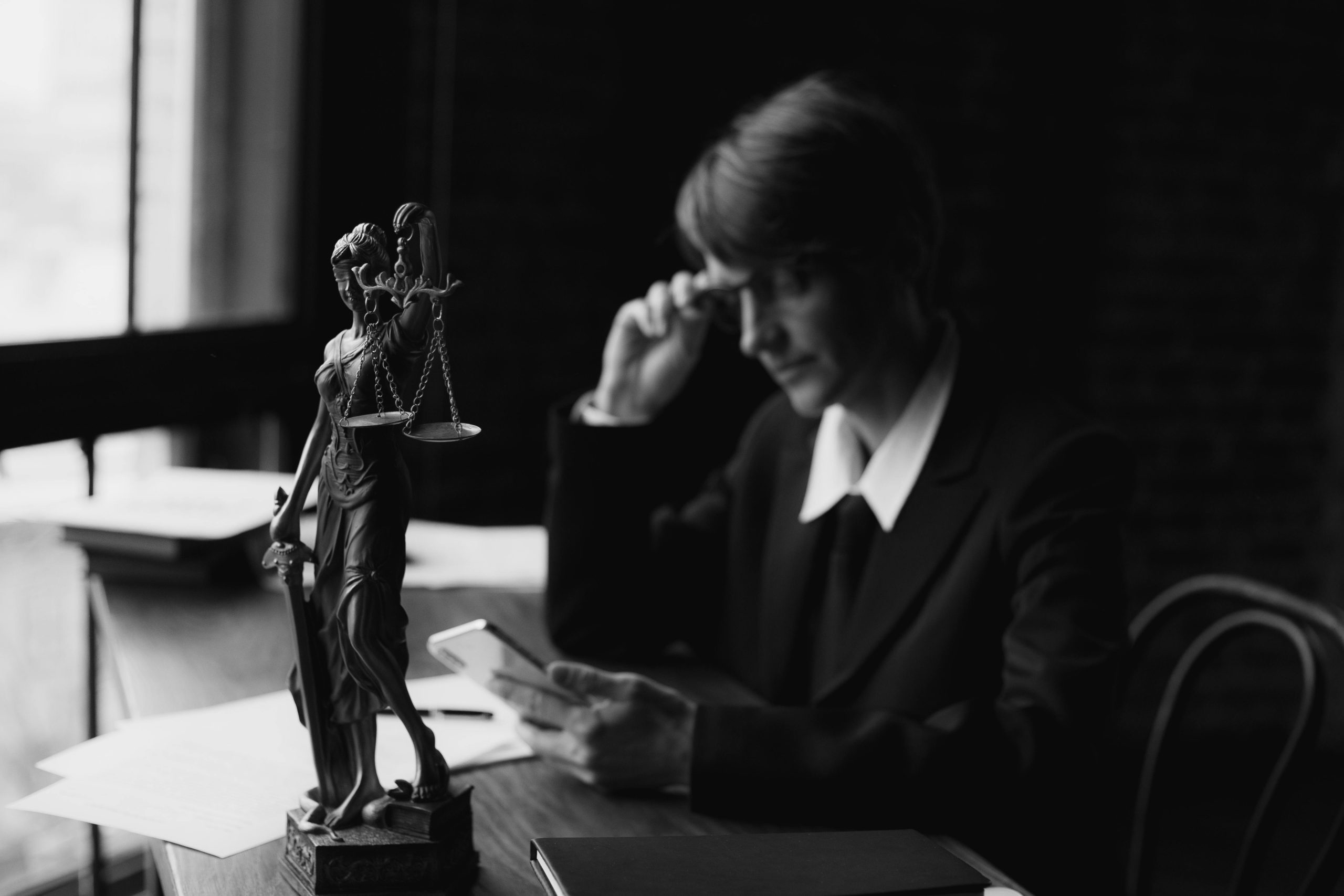 A lawyer is sitting at her desk reviewing materials that to ensure she has done her due diligence