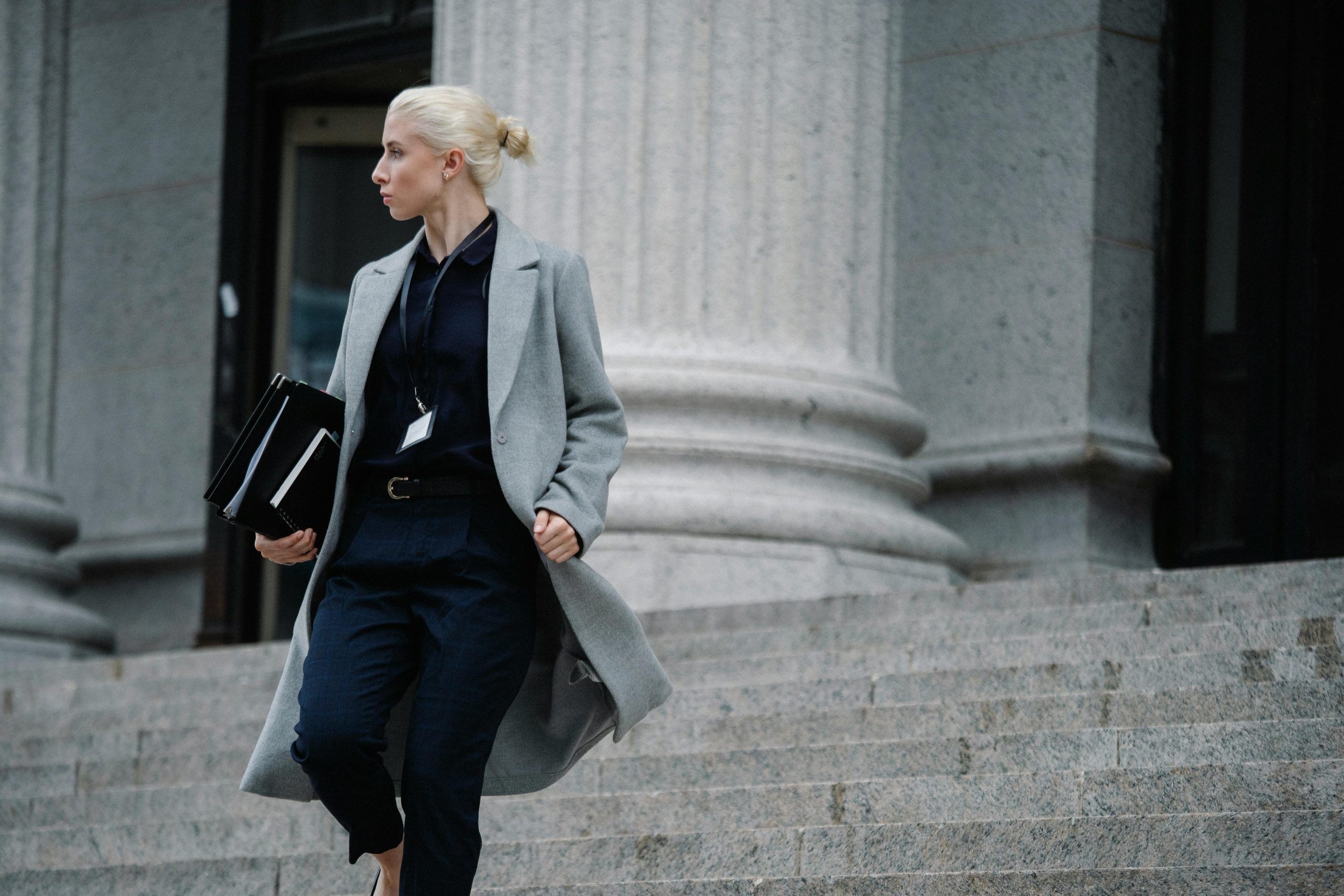 A female legal interpreter walks down the steps on the court house.
