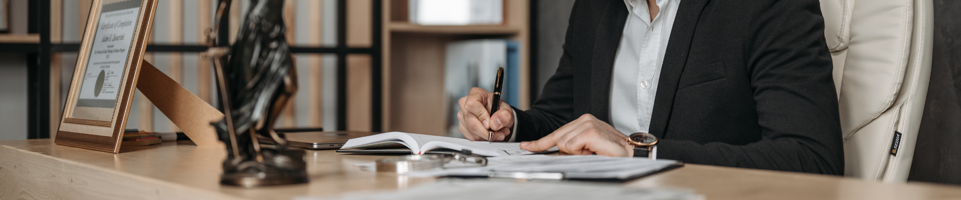 A certified court translator prepares for a case to make sure it's admissible. She sits at the desk with a pen and notepad in front of her.