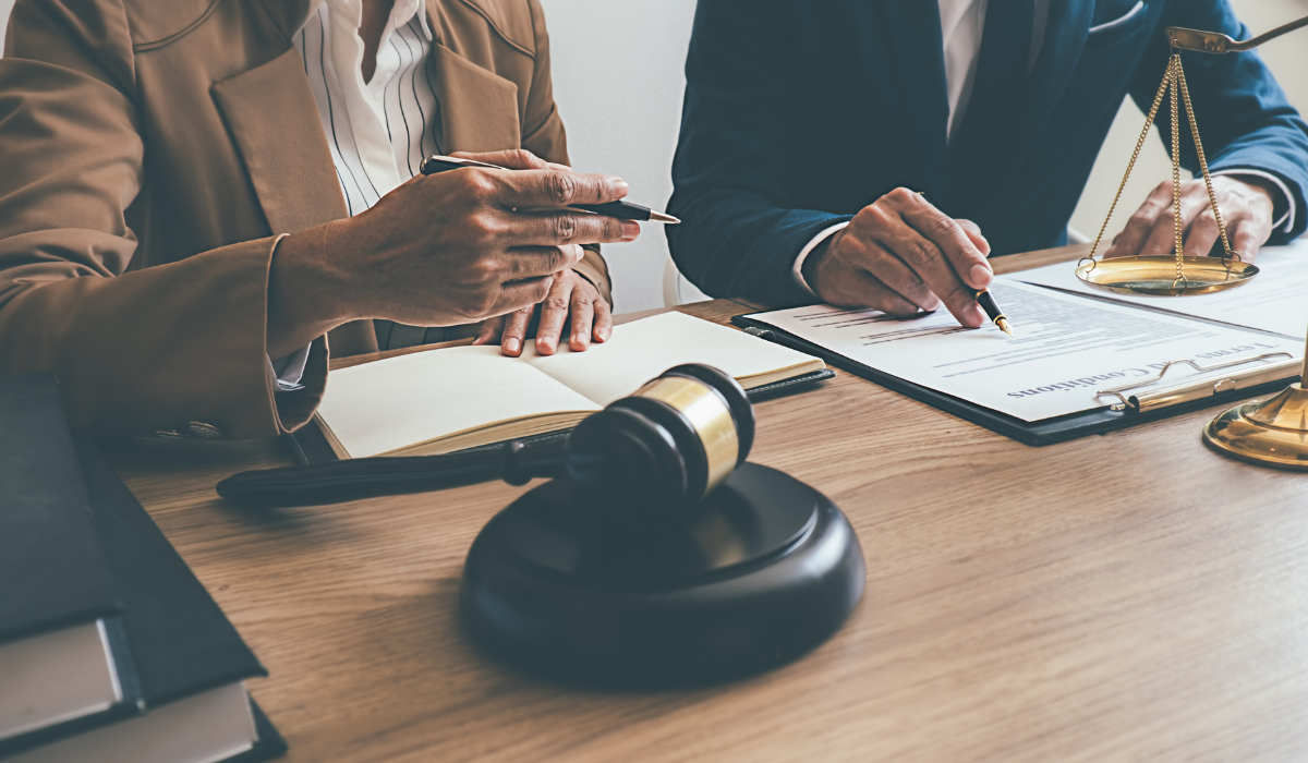 Two people in business attire carefully review documents pertaining to a multilingual court case to promote legal compliance.