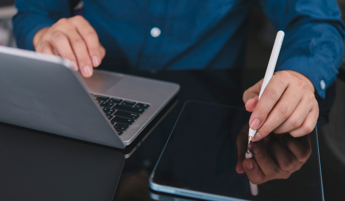 A certified legal translator uses an electronic tablet and laptop for paperless legal translation.